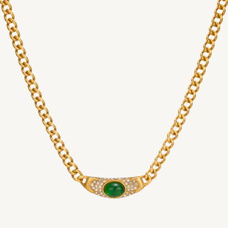 Gold necklace with a green gemstone and small diamonds on a white background
