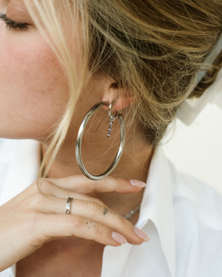 woman displaying earrings and a ring