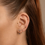 Nadare Co. Astra threadless earring featuring a gold star with a clear CZ and a dangling sapphire blue CZ drop.