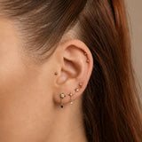 Nadare Co. Astra threadless earring featuring a gold star with a clear CZ and a dangling sapphire blue CZ drop.