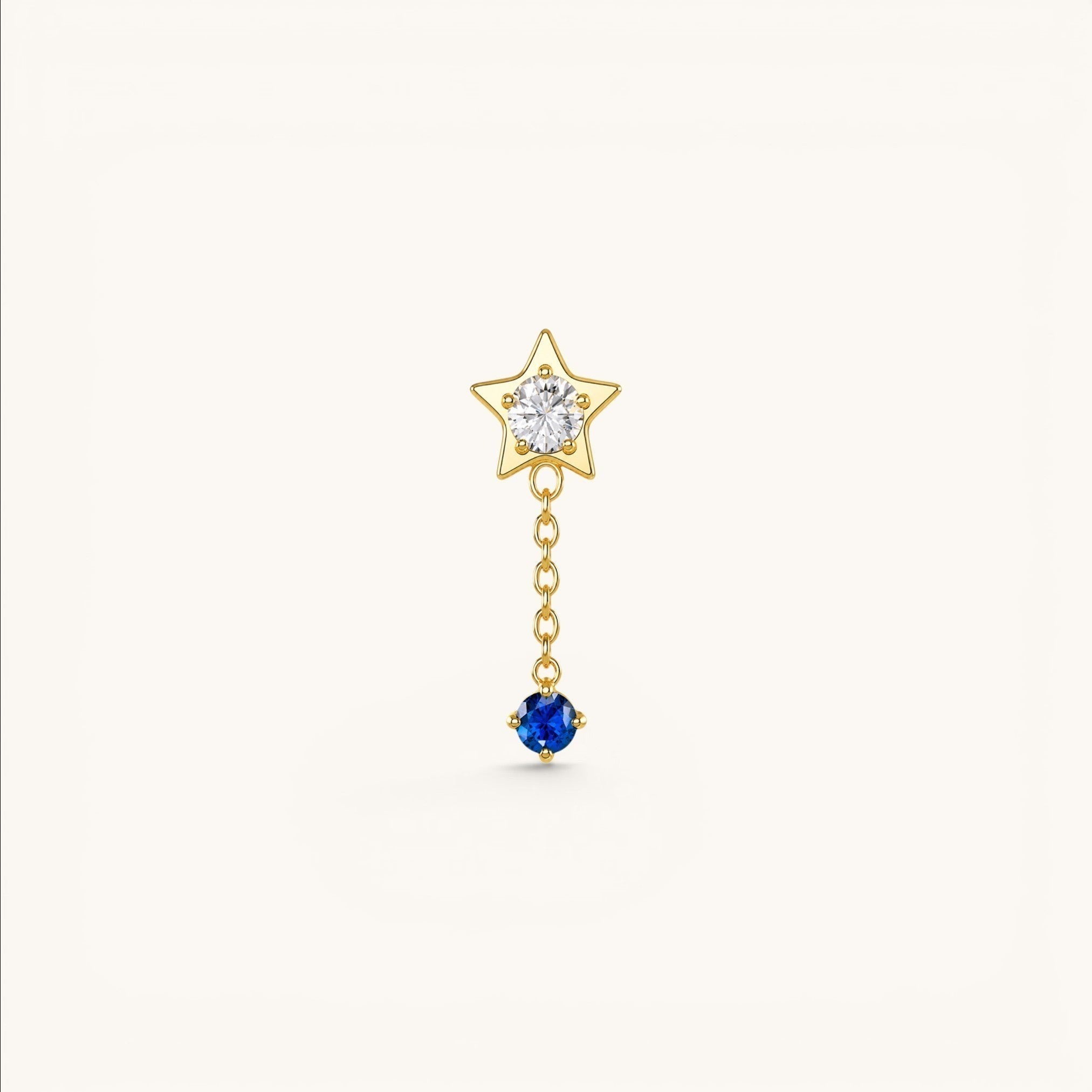 Nadare Co. Astra threadless piercing jewelry featuring a gold star with clear CZ and a sapphire blue CZ drop chain.