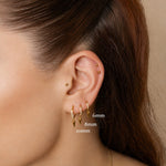 Nadare Co. Atlas Clicker Ring with cubic zirconia and removable spike charm worn in multiple ear lobe piercings.