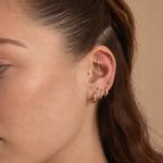 Nadare Co. Atlas Clicker Ring with cubic zirconia and a removable spike charm worn in a model's helix piercing.