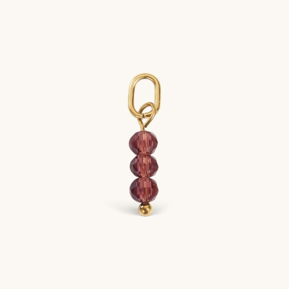 Nadare Co. Birth Month Bead Charm featuring three faceted purple beads on a gold jump ring for necklace stacking.