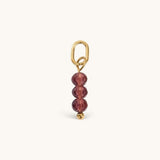 Nadare Co. Birth Month Bead Charm featuring three faceted purple beads on a gold jump ring for necklace stacking.