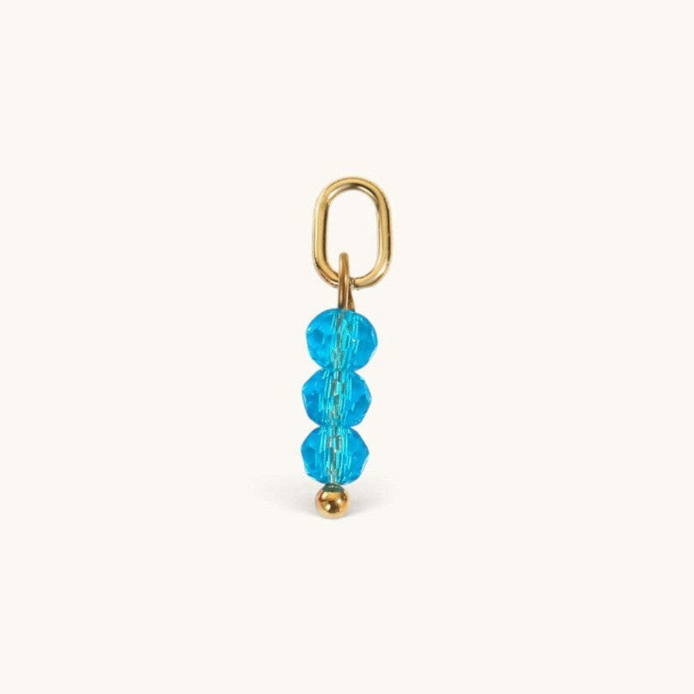 Nadare Co. birth month charm with three faceted bright blue beads and a gold jump ring for necklace stacking.