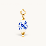 Nadare Co. oval porcelain charm with blue floral pattern and 14k gold plated stainless steel accents.