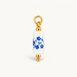 Nadare Co. blue floral porcelain tube bead charm with 14k gold plated stainless steel accents.