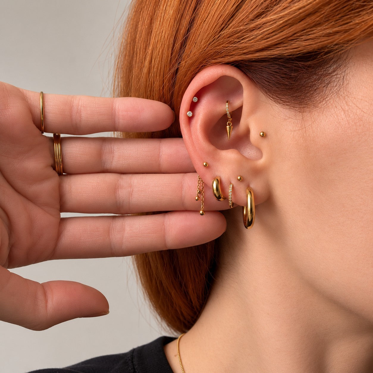 Nadare Co. Cascade Ear Charm featuring three delicate gold chains with polished beads worn on a gold hoop earring.