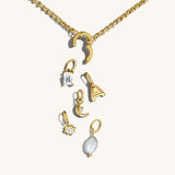 Nadare Co. customizable gold chain necklace with a clasp and various charms including a pearl, letter, and crystals.