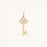 Nadare Co. gold key charm pendant featuring delicate pavé-set diamonds on the bow and bit against a neutral background.
