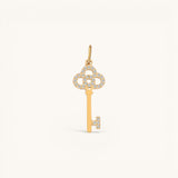 Nadare Co. gold key charm pendant featuring delicate pavé-set diamonds on the bow and bit against a neutral background.