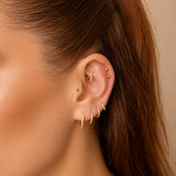 Nadare Co. Elodie Clicker Ring in gold-plated titanium with pavé cubic zirconia worn in a curated ear piercing stack.