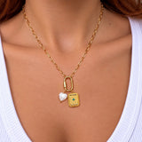 Nadare Co. gold chain necklace featuring a vintage-style rectangular tablet charm with a green stone and heart charm