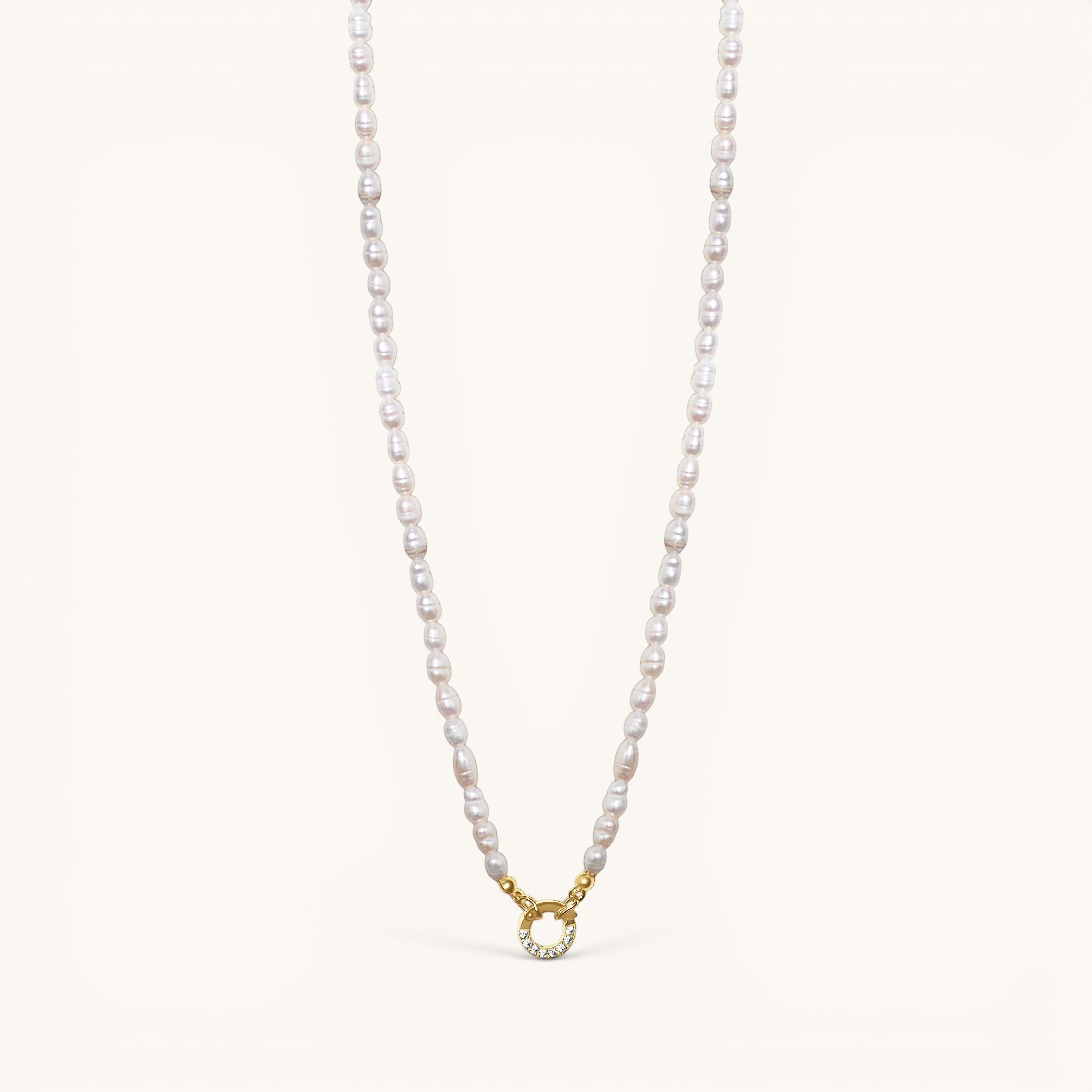 Nadare Co. freshwater pearl necklace with a gold-toned circular clasp featuring small embedded crystals.