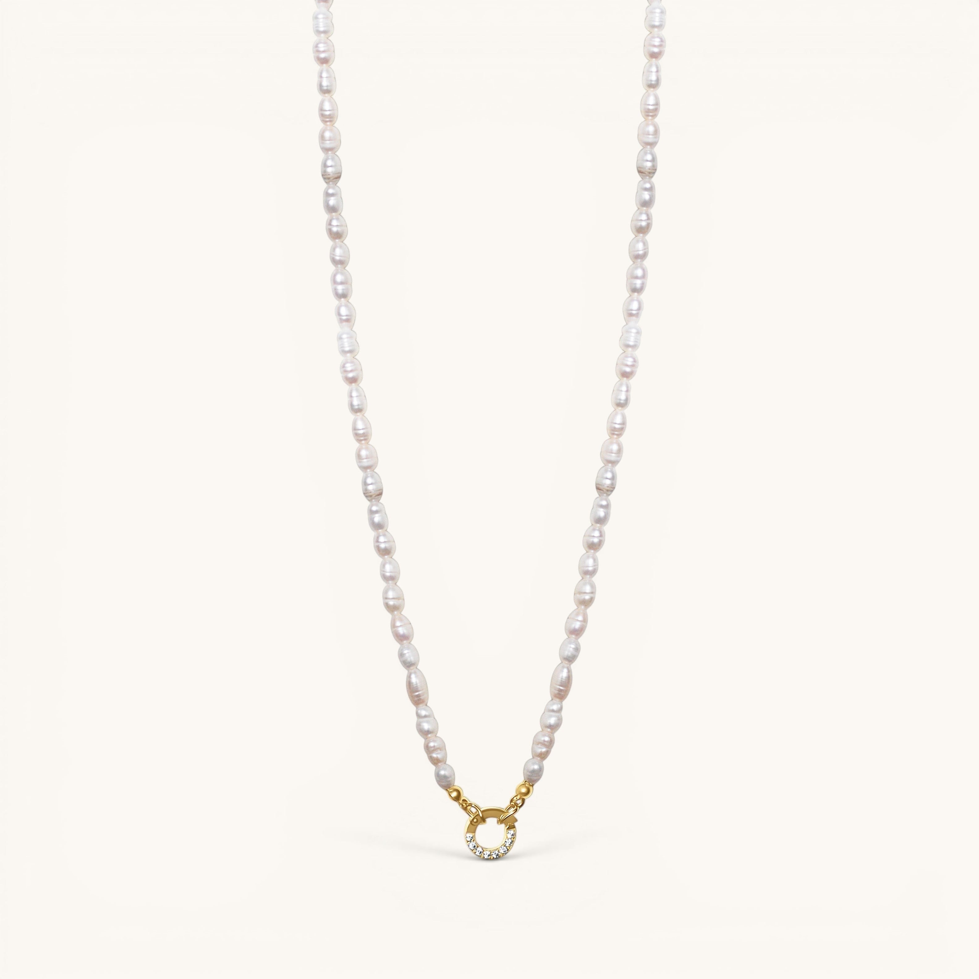 Nadare Co. freshwater pearl necklace with a gold-toned circular clasp featuring small sparkling crystals.