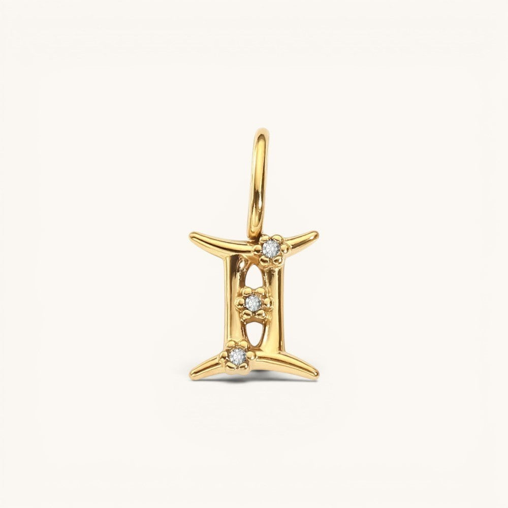 Nadare Co. Gemini zodiac charm in 14k gold-plated stainless steel with sparkling cubic zirconia accents.