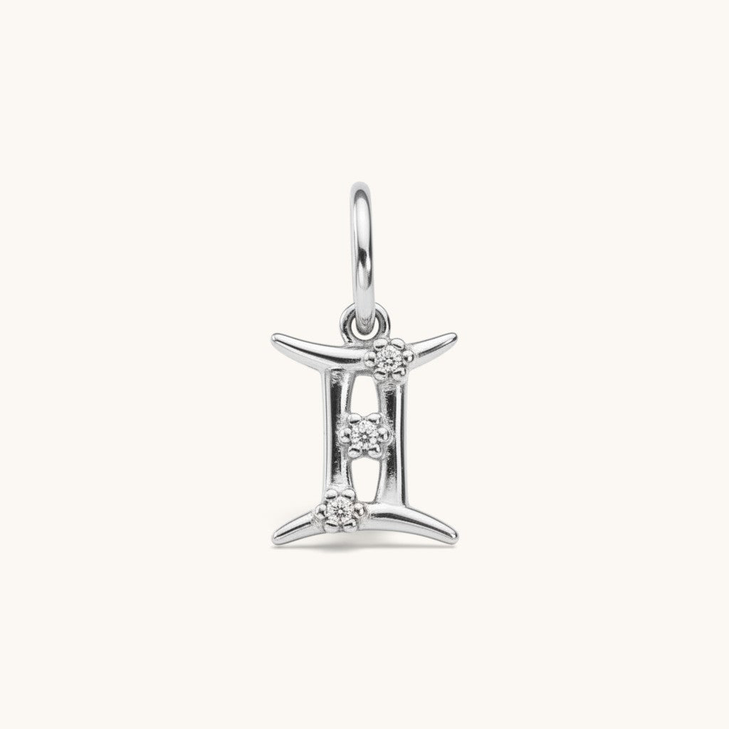 Nadare Co. silver Gemini zodiac charm featuring three small cubic zirconia stones on a stainless steel pendant.