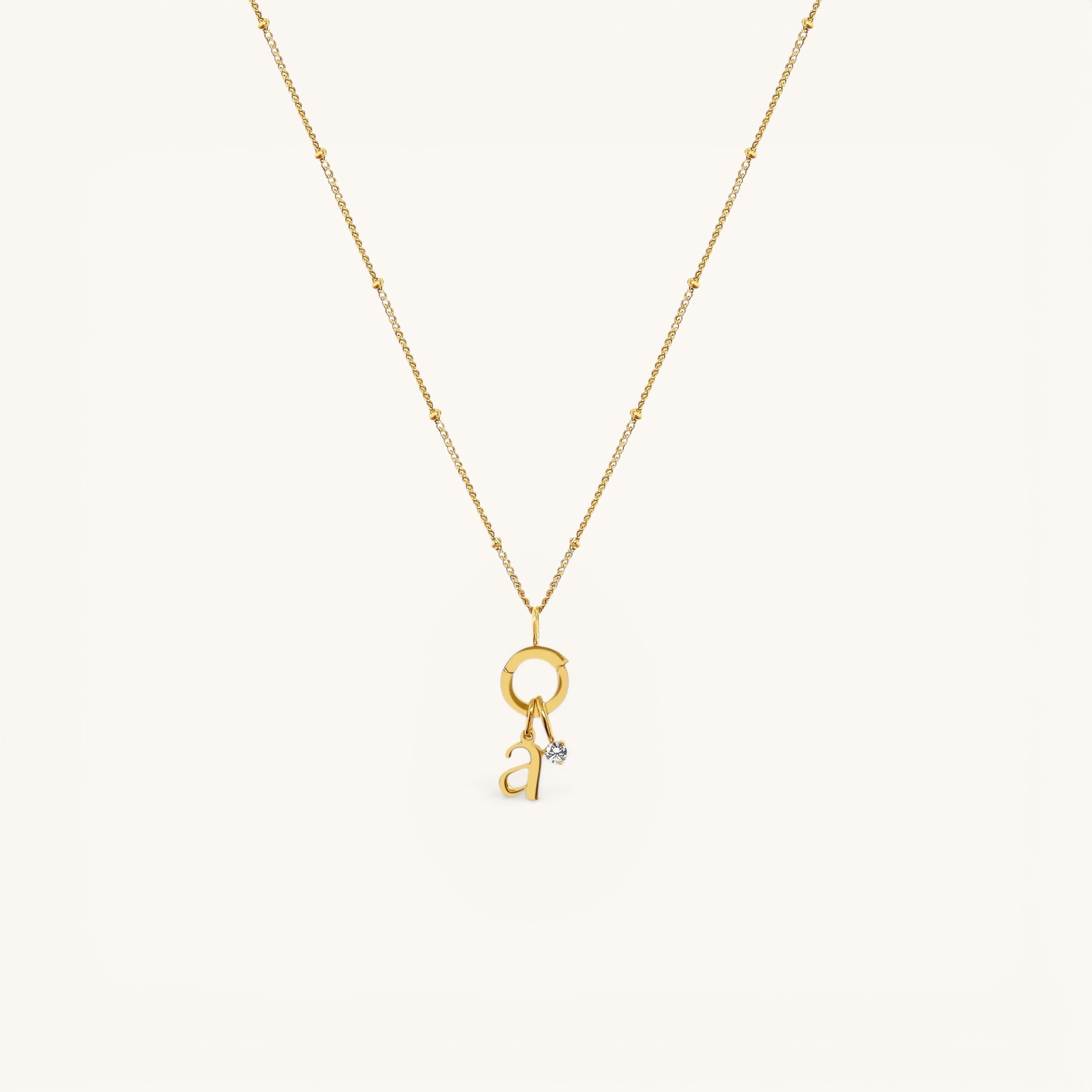 Nadare Co. gold-plated stainless steel necklace featuring a delicate chain and a mini birthstone charm with a letter.