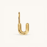 Nadare Co. gold-plated stainless steel bubble initial charm in the shape of the letter U with a rounded puffed design.