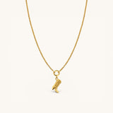 Nadare Co. gold necklace featuring a detailed cowboy boot charm on a delicate chain against a cream background.