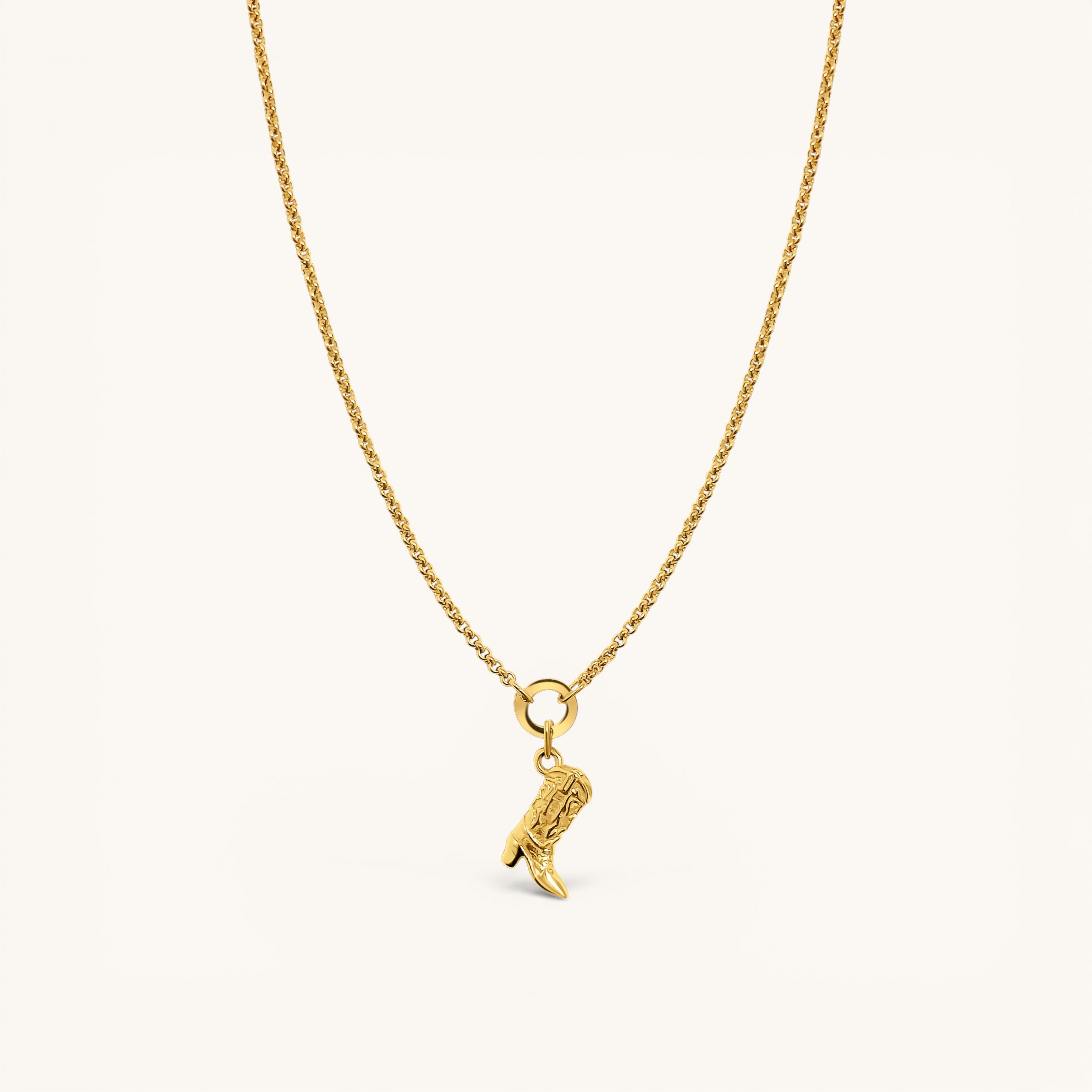 Nadare Co. gold necklace featuring a detailed cowboy boot charm on a delicate chain against a cream background.