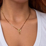 Nadare Co. gold dolphin charm necklace on a delicate chain worn around a woman's neck