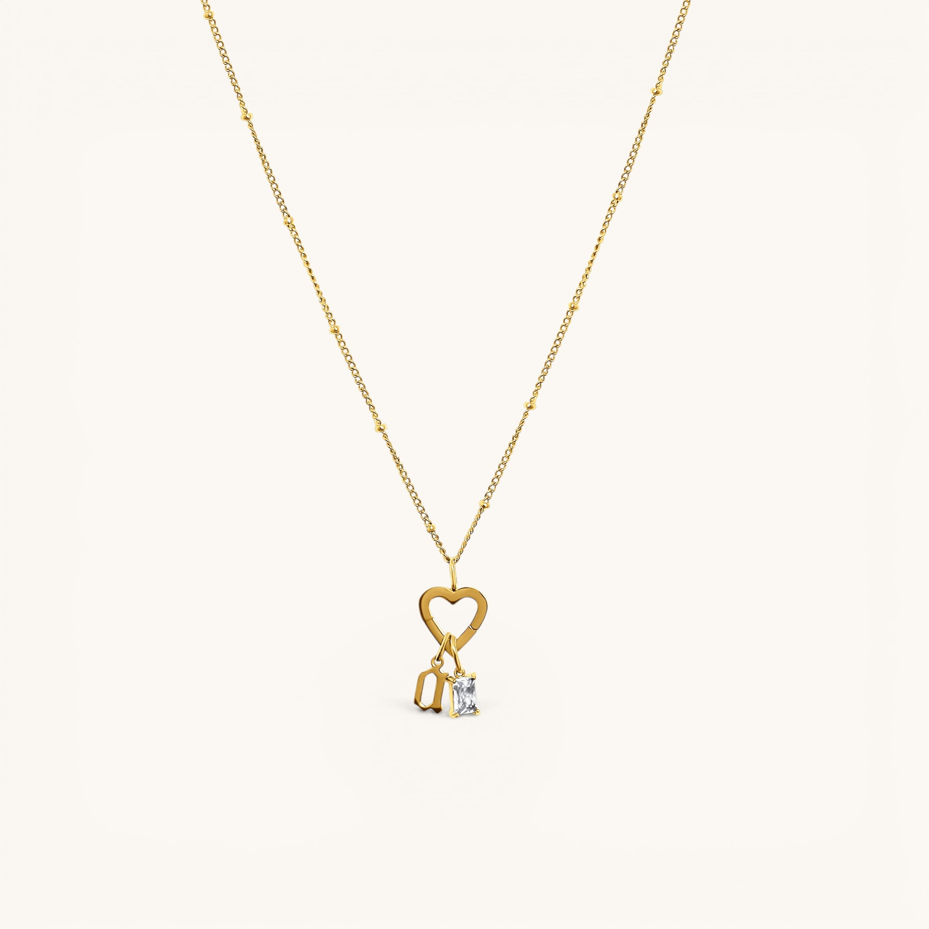 Nadare Co. gold gothic initial charm on a delicate beaded chain with a heart clasp and a small baguette crystal