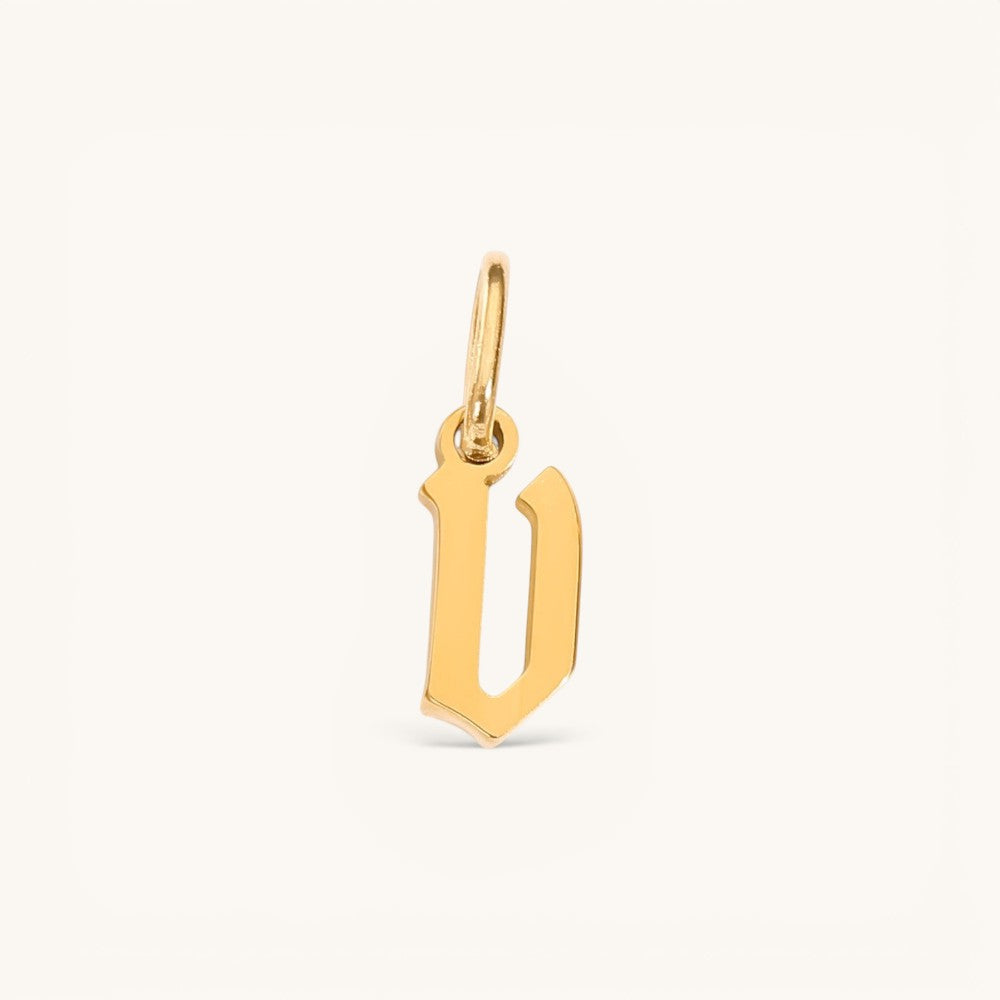 Nadare Co. gold-plated stainless steel gothic letter D charm with sharp edges and old-English style typography.