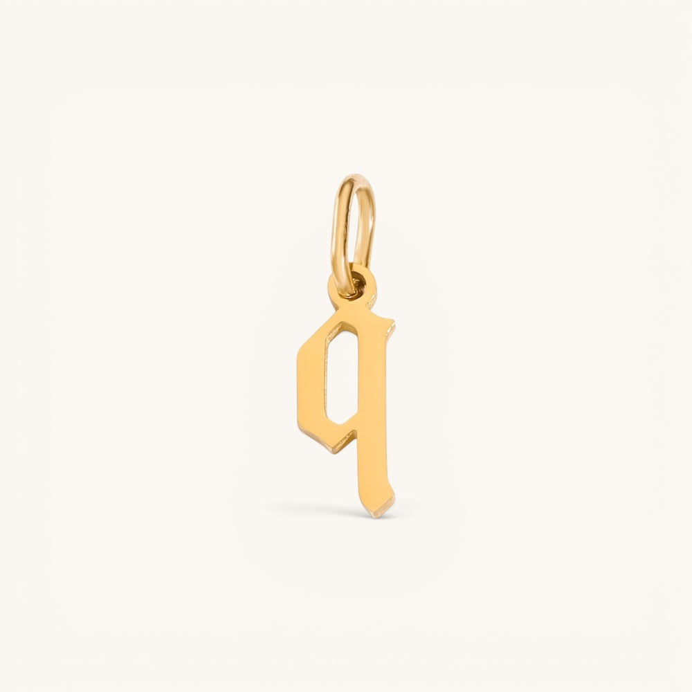Nadare Co. gothic letter q charm in 14k gold plated stainless steel with sharp edges and a polished finish.