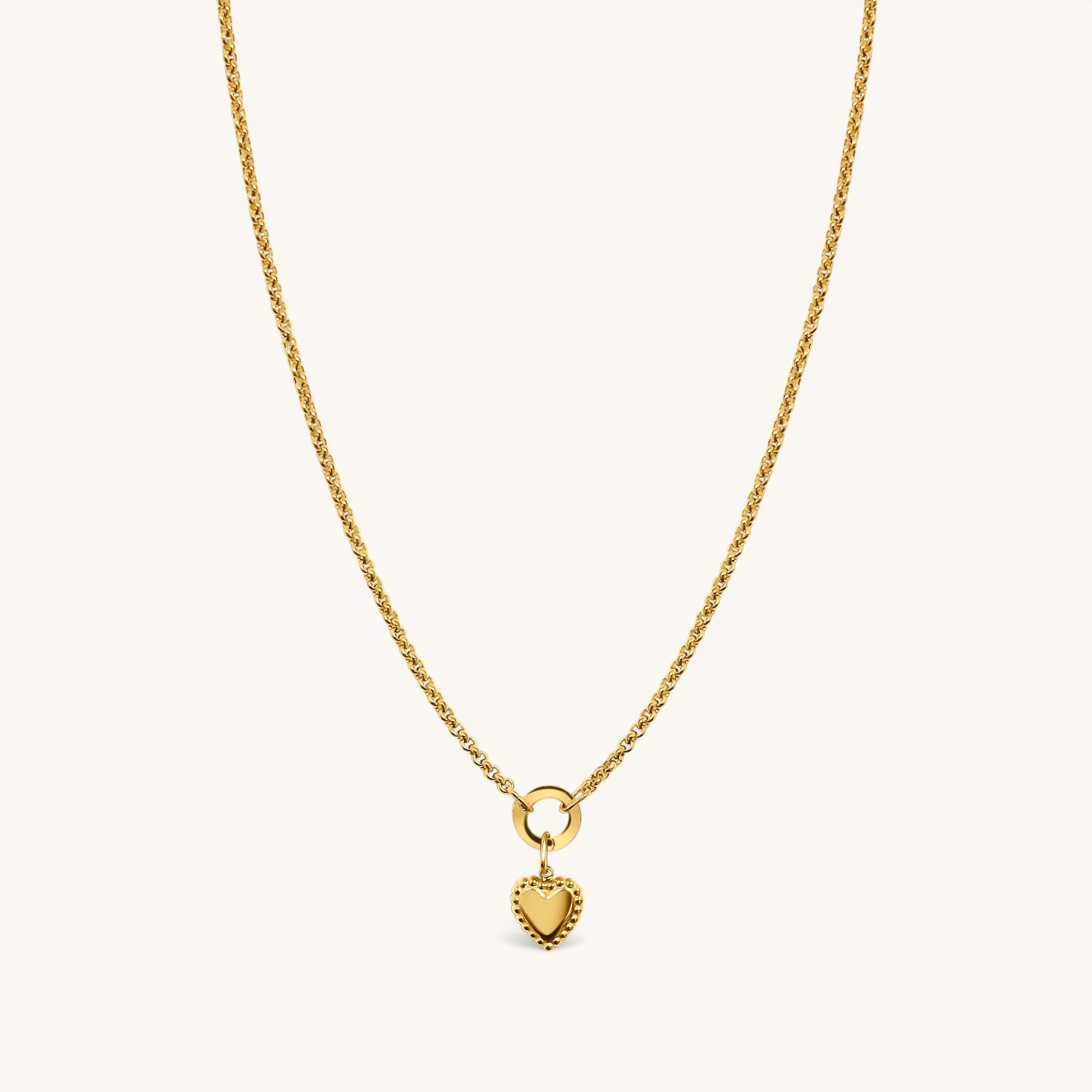 Nadare Co. gold chain necklace featuring a delicate heart charm with a beaded edge on a circular pendant bail.