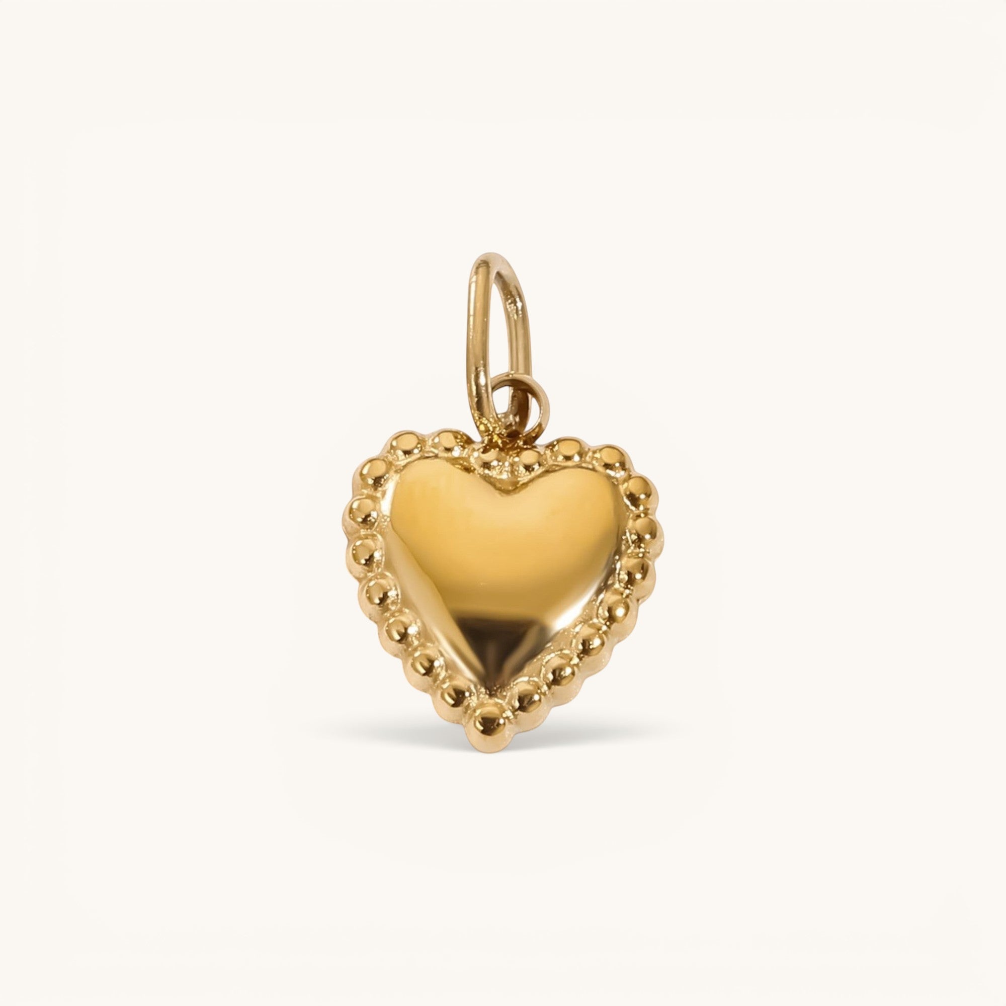 Nadare Co. gold heart charm pendant with a delicate beaded edge detail on a plain background.