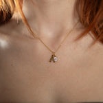 Nadare Co. gold initial A pendant necklace with a sparkling round birthstone charm worn on a delicate chain.
