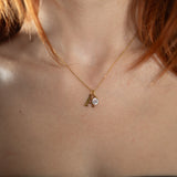 Nadare Co. gold initial A pendant necklace with a sparkling round birthstone charm worn on a delicate chain.