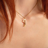 Nadare Co. gold initial necklace with a delicate mini birthstone charm worn on a person's neck