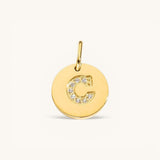 Nadare Co. gold initial charm with pavé set diamonds on a polished disc, letter C.