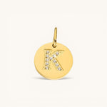 Nadare Co. gold initial charm with pavé set crystals on a polished disc, letter K.
