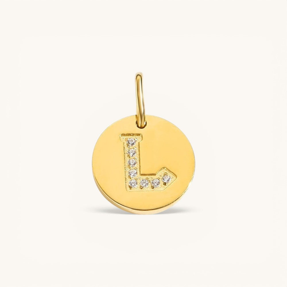 Nadare Co. gold initial charm with pavé diamond letter L on a polished disc.