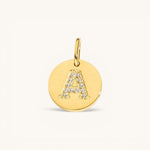 Nadare Co. gold initial charm with pavé diamond letter A on a polished disc.