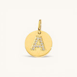 Nadare Co. gold initial charm with pavé diamond letter A on a polished disc.