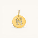 Nadare Co. gold initial charm with pavé diamond letter N on a polished disc.