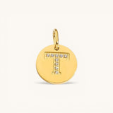 Nadare Co. gold initial charm with pavé set cubic zirconia stones forming the letter T on a polished disc.