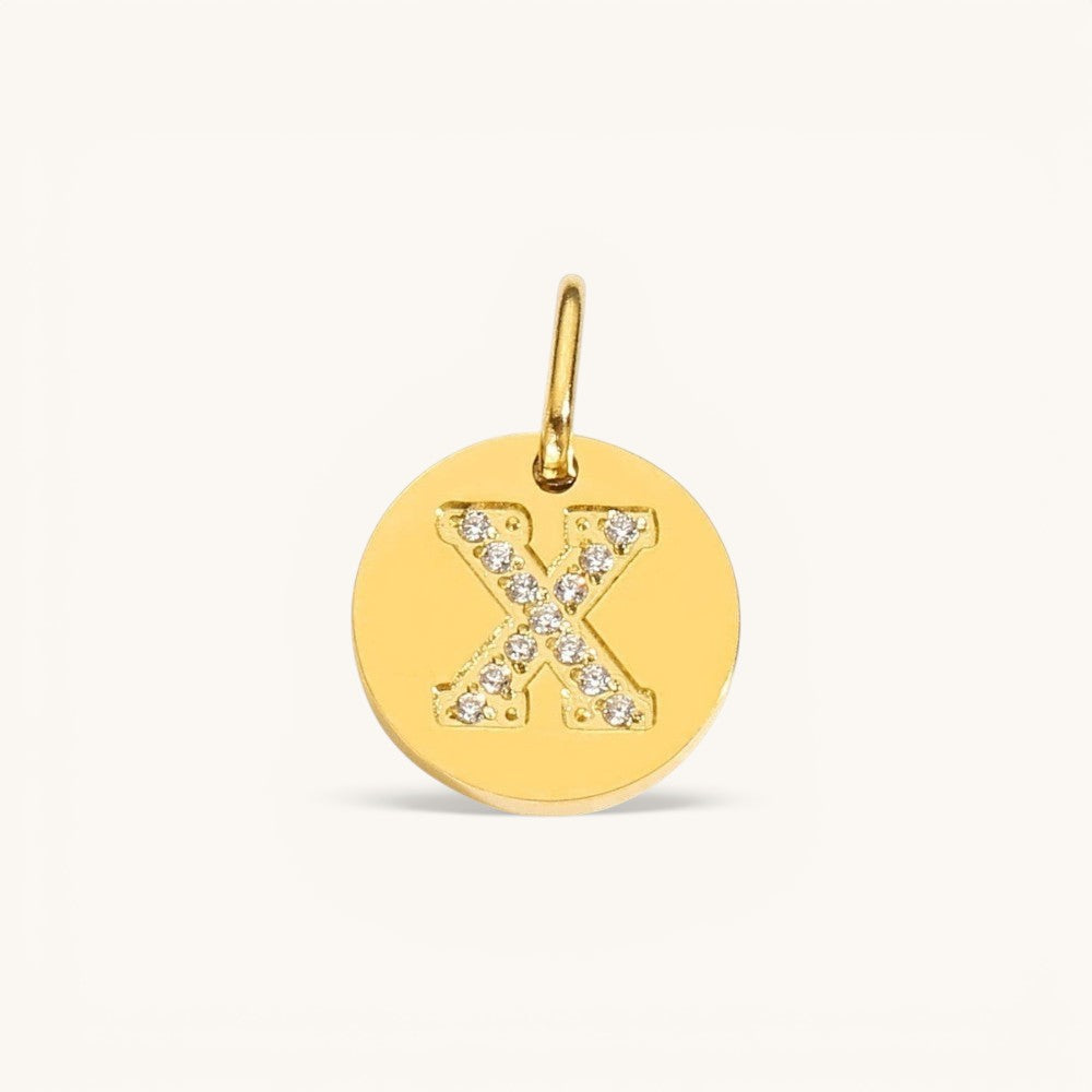 Nadare Co. gold initial charm with pavé set crystals forming the letter X on a polished disc.