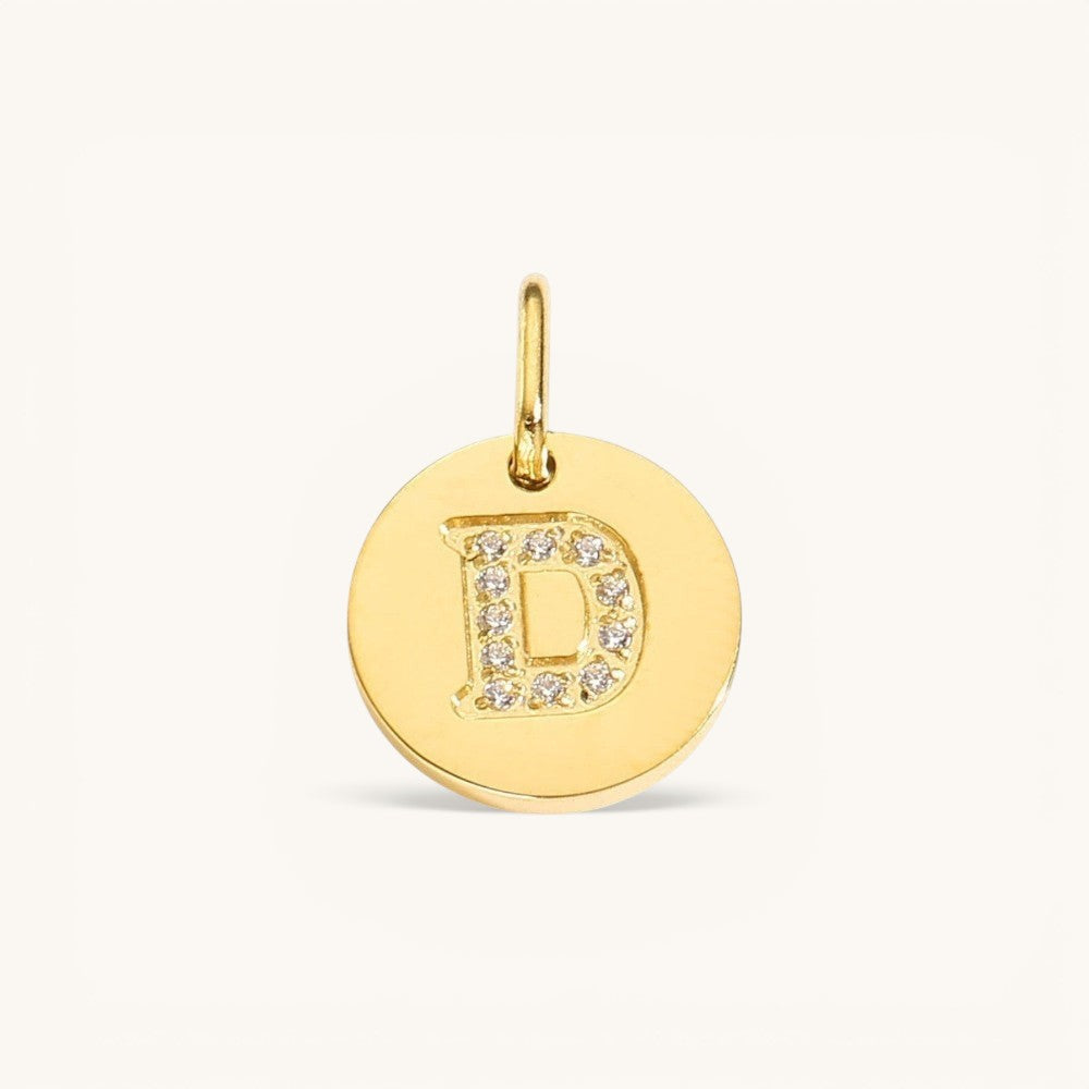 Nadare Co. gold initial D charm with pavé diamond detailing on a polished disc.