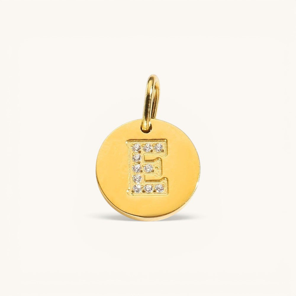 Nadare Co. gold initial E charm with pavé diamond accents on a polished disc.