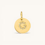 Nadare Co. gold initial G charm with pavé set diamonds on a polished disc.