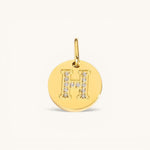 Nadare Co. gold initial H charm with pavé diamond accents on a polished disc.