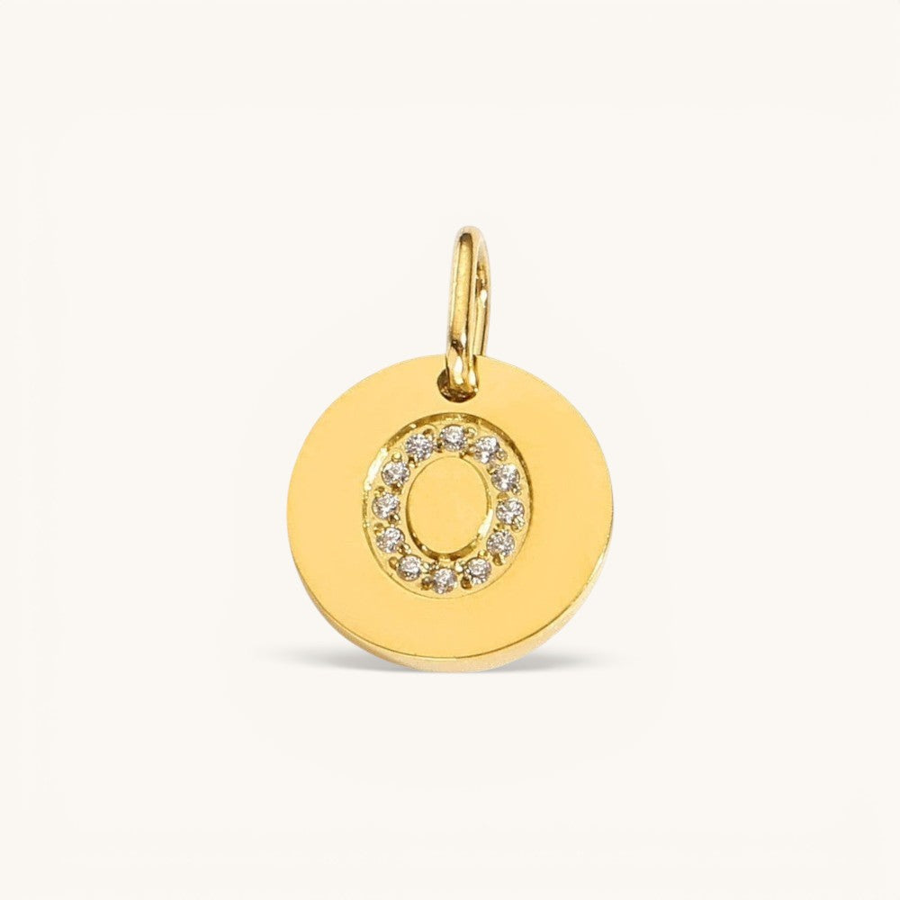 Nadare Co. gold initial "O" charm with pavé diamonds on a polished disc.