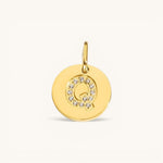 Nadare Co. gold initial Q charm with pavé crystal accents on a polished disc.