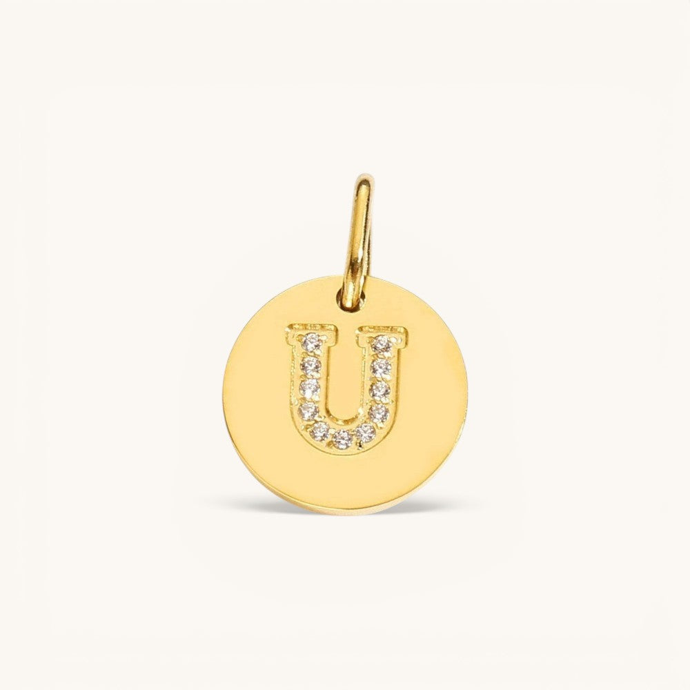 Nadare Co. gold initial U charm with pavé crystal detailing on a polished disc.